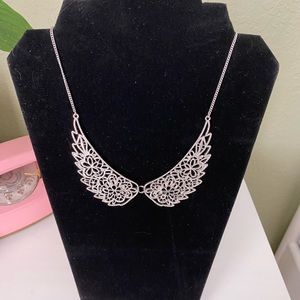 Silver tone wing necklace.